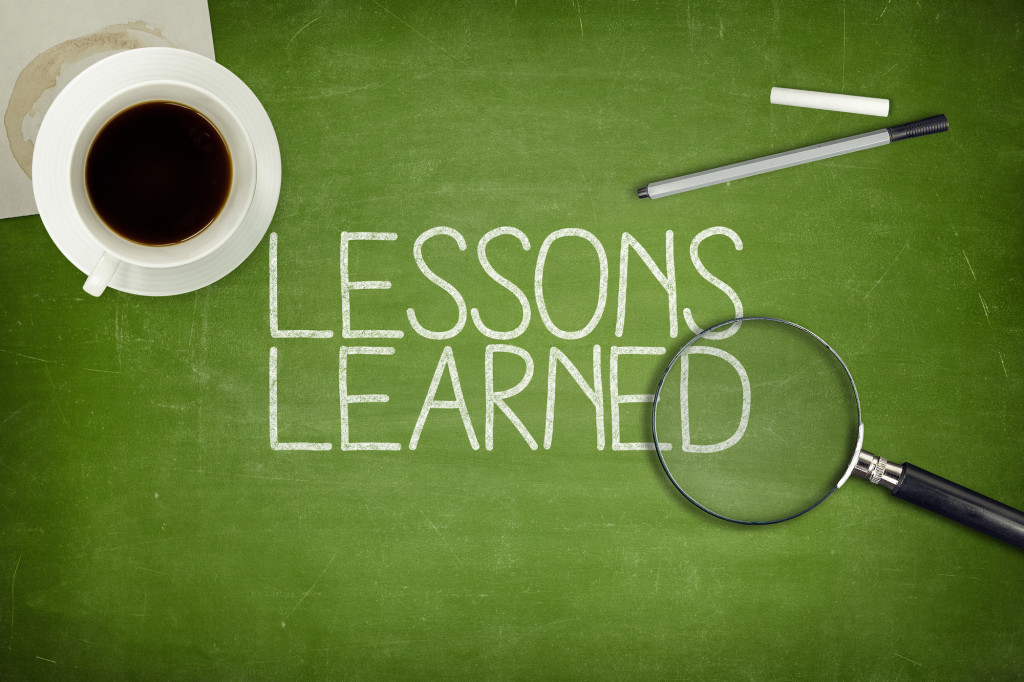 Lessons learned concept on green blackboard with coffee cupt and paper plane